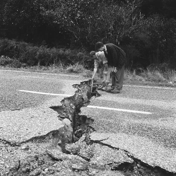 Geologists measure the vertical movement across a rupture created by the earthquake. The side they are standing on has moved downwards relative to the rest of the road. [GNS Science]