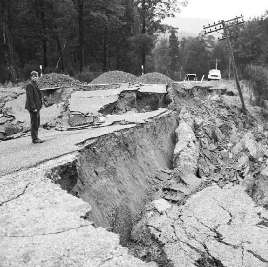 Geologist John Foster stands at the destroyed road, SH6 east of Inangahua. [GNS Science]