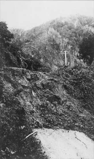 The White Creek Fault scarp, cutting across a road in the Buller Gorge. The scarp, visible as a rocky cliff face, is the result of vertical movement on the fault that displaced the road, leaving one side over 4m higher than the other. [GNS Science]