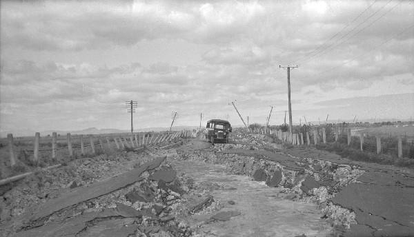 Severe surface damage left this road almost impassable after the 1931 earthquake. Note the dislodged power poles in the background. [GNS Science]