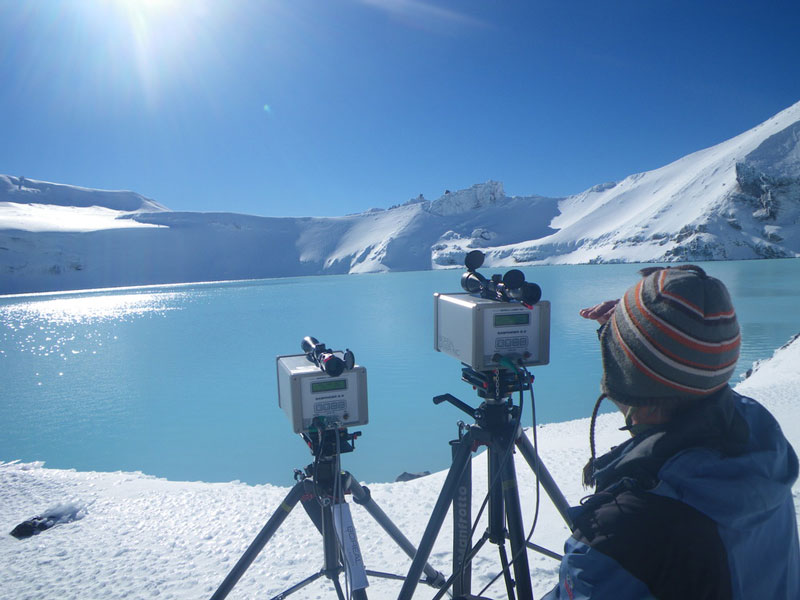 A scientist sitting beside Ruapehu Crater Lake using a Laser Diode.