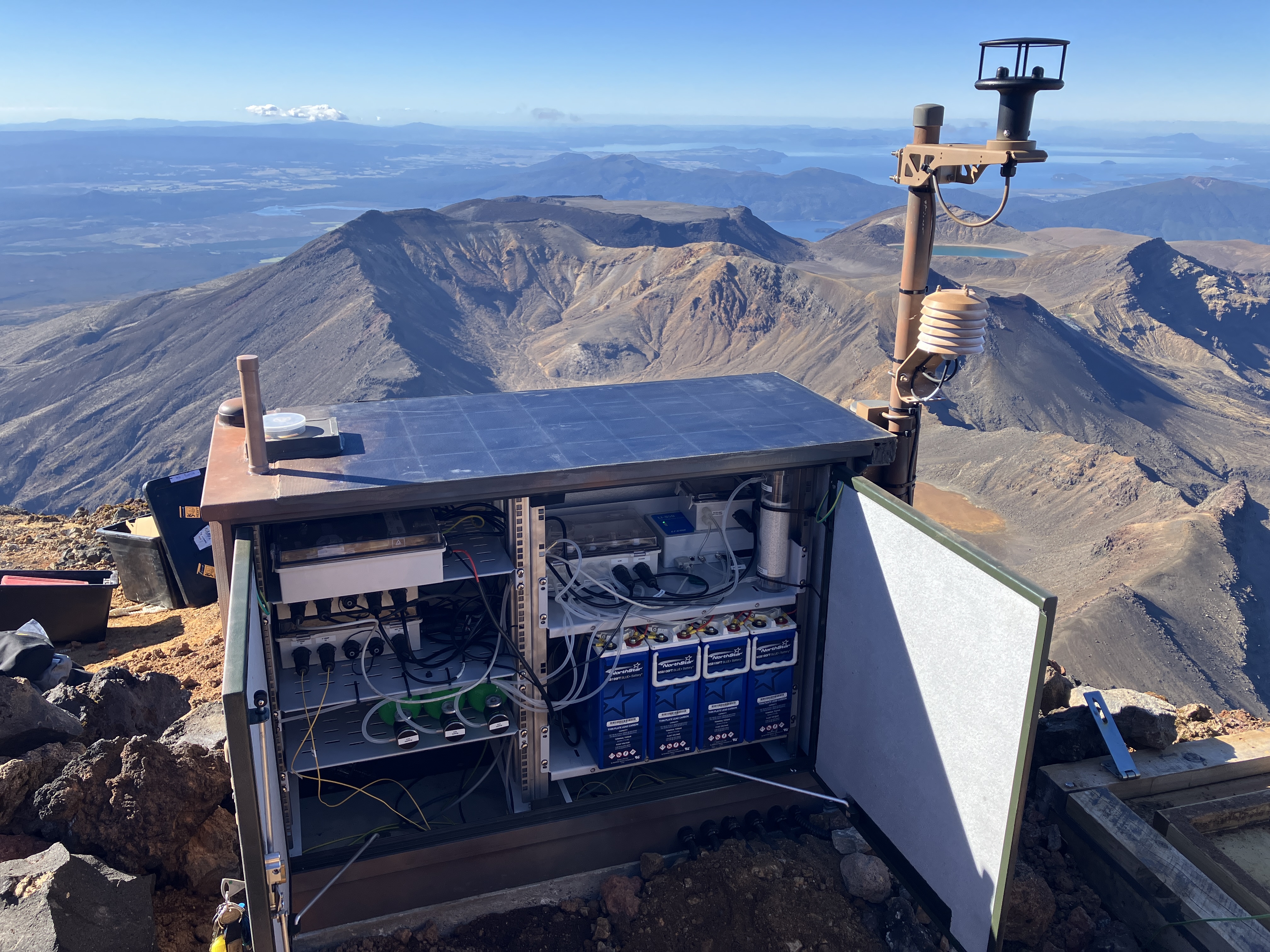 A close up of the cabinet containing a multigas system. The cabinet contains the multigas data logger and tubes to deliver air to the sensors, as well a batteries and communications equipment to operate the site.